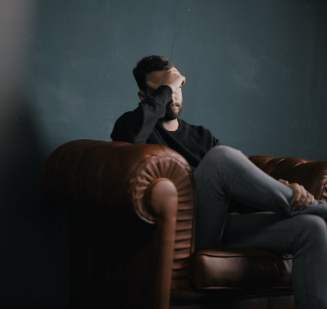 man in chair thinking sad thoughts