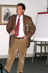 Man in brown presenting