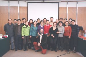 Large group of people posing for a photo in a conference room in China.