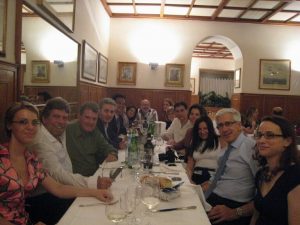 Group of people seated at a long table smiling for the photo.