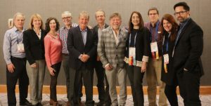 Group of psychologists in formal attire posing at a conference.